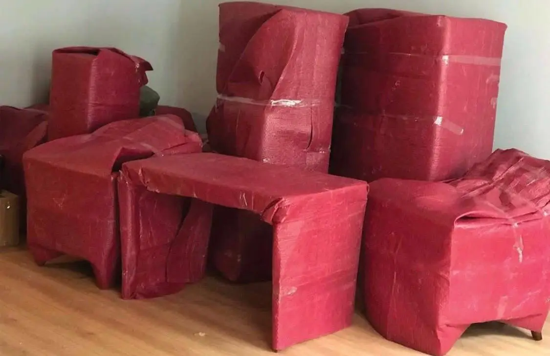 Beykoz nakliyat: kırmızı koruyucuyla paketlenmiş masa ve koltuklar